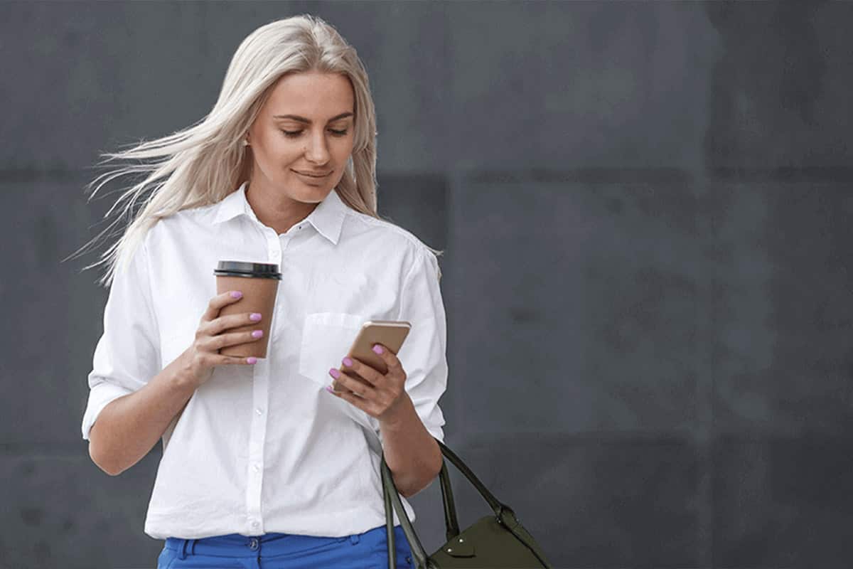Nő nézi a telefonját.